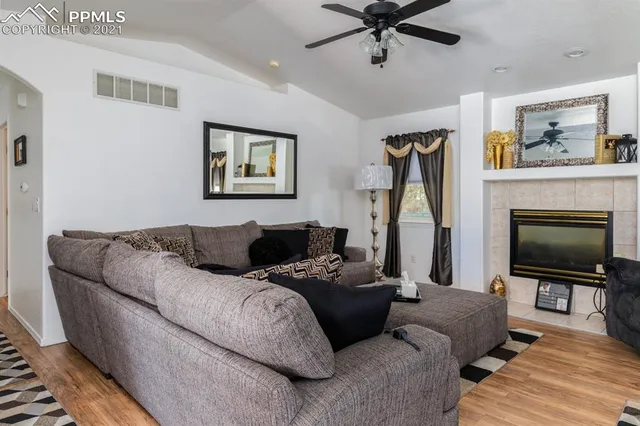 a living room with furniture a flat screen tv and a fireplace