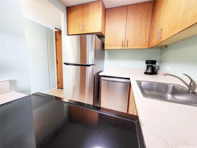 a kitchen with stainless steel appliances a refrigerator a sink a stove and cabinets