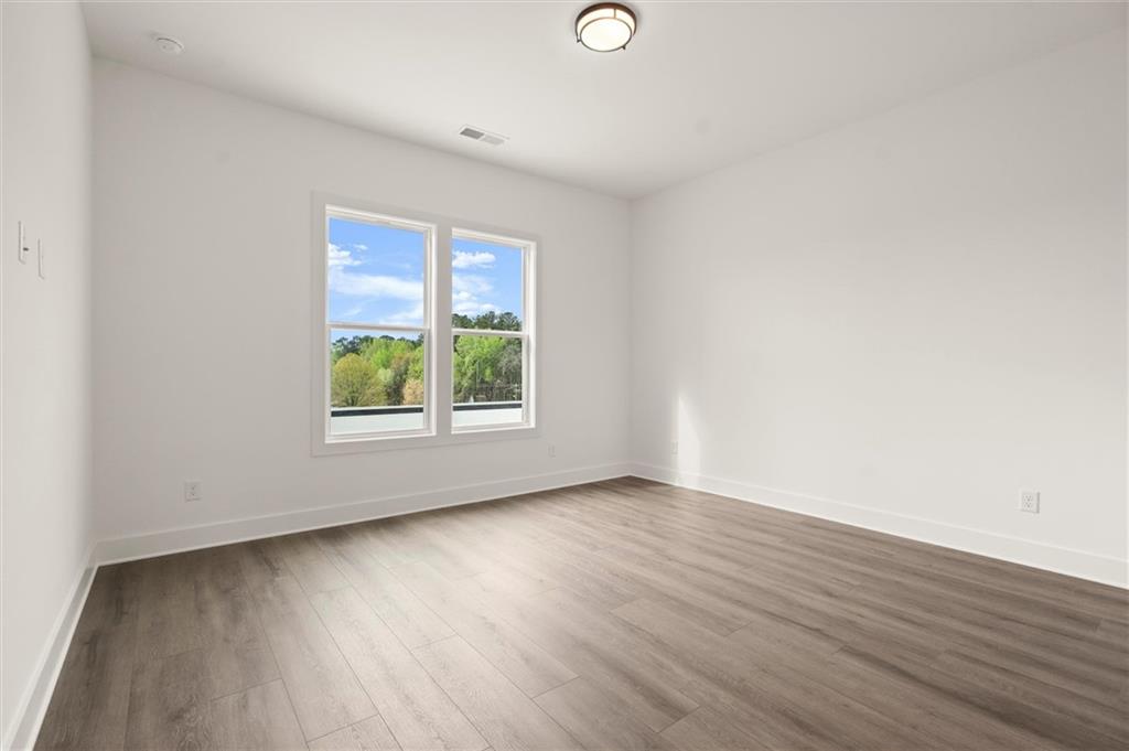 322 Treble Way Alpharetta, GA 30009 - Photo 40 of 67 an empty room with wooden floor and windows