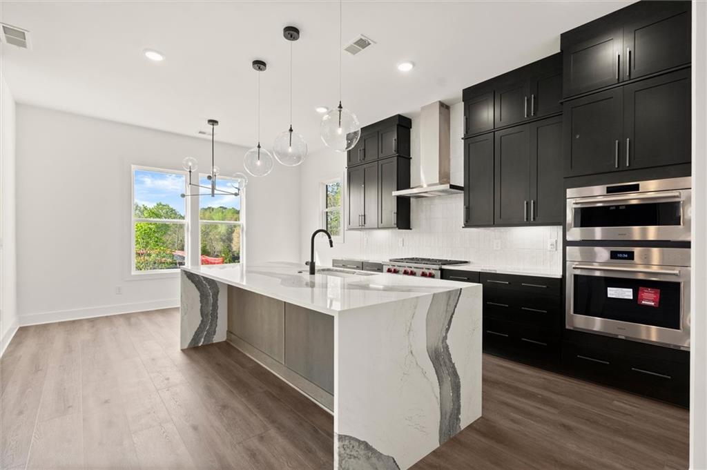 322 Treble Way Alpharetta, GA 30009 - Photo 10 of 67 a large kitchen with stainless steel appliances kitchen island granite countertop a stove a sink and a refrigerator