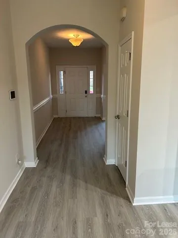 an empty room with wooden floor and mirror