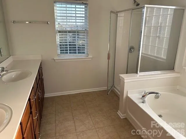 a bathroom with a tub sink and mirror