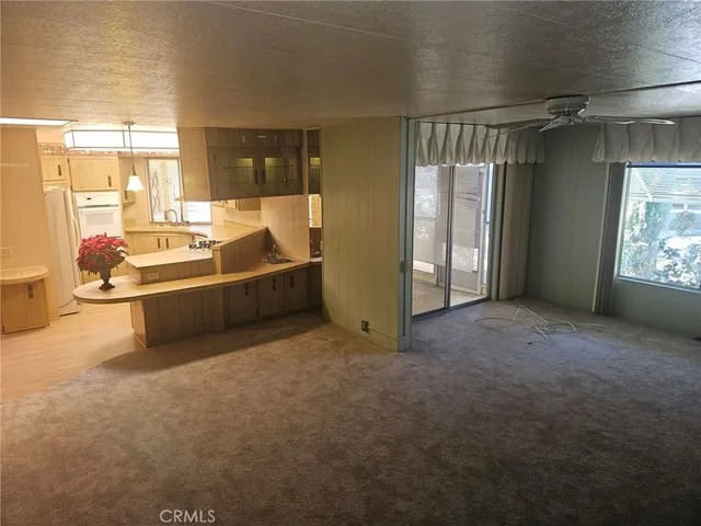 a view of a big room with windows and chandelier