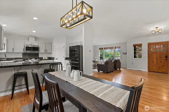 a kitchen with a table chairs refrigerator and microwave