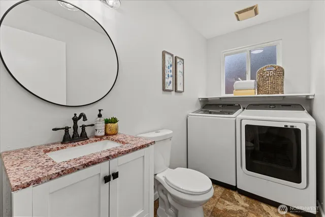 a bathroom with a toilet a sink and mirror