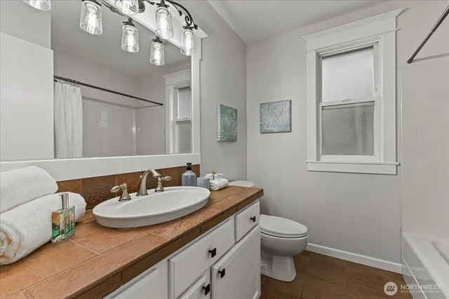a bathroom with a granite countertop sink a toilet and a mirror
