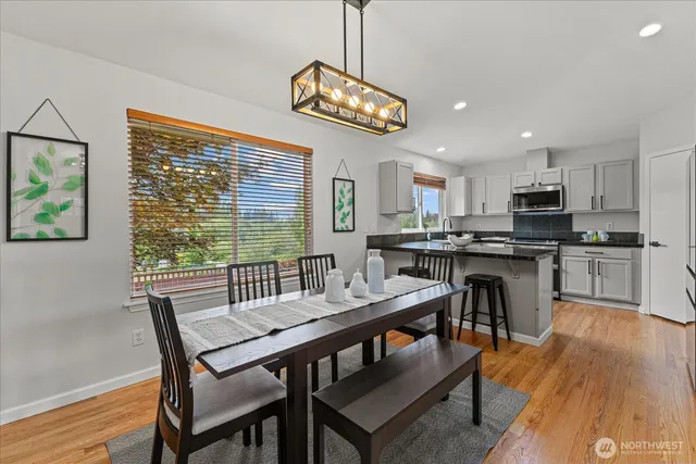 a view of a dining room with furniture a chandelier and wooden floor