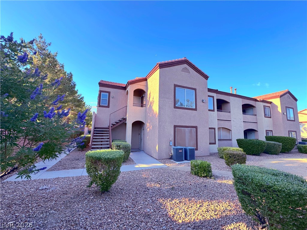 9580 West Reno Avenue, Unit 242 Las Vegas, NV 89148 - Photo 2 of 26 A well-maintained stucco exterior features multiple balconies and a vibrant xeriscape landscape.