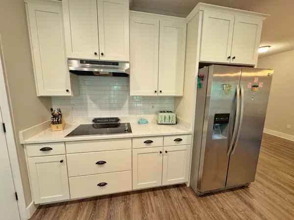 a kitchen with granite countertop cabinets stainless steel appliances and wooden floor