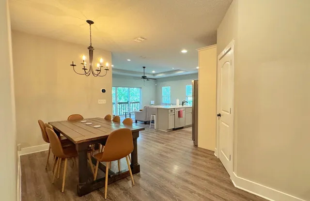 a view of a dining room with furniture and chandelier