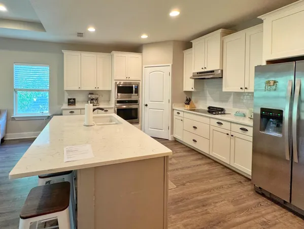 a kitchen with stainless steel appliances a stove a sink a microwave and cabinets