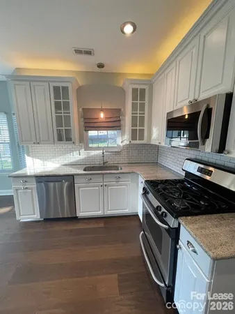 a kitchen with granite countertop a stove and a sink