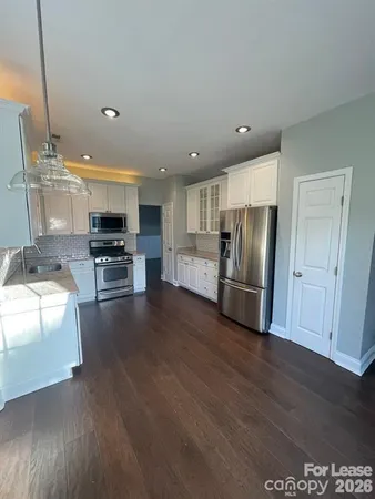 a kitchen with stainless steel appliances a refrigerator and a stove top oven