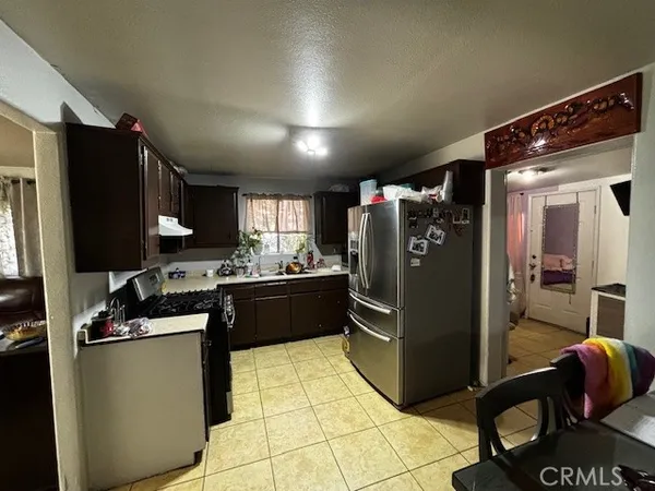 a kitchen with granite countertop a refrigerator and a stove top oven