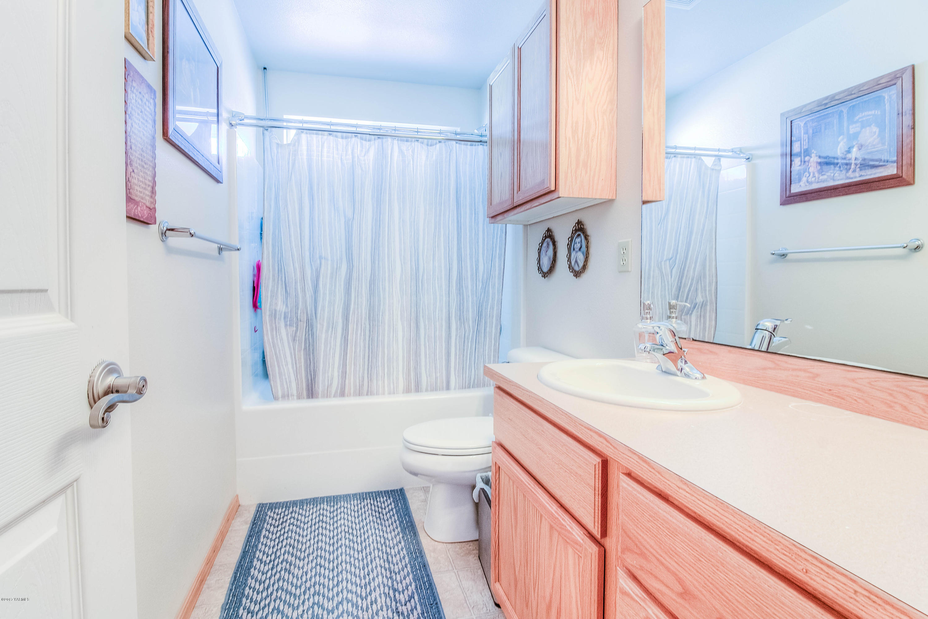 205 Beane Road Moxee, WA 98936 - Photo 18 of 28 a bathroom with a sink a toilet and shower curtain