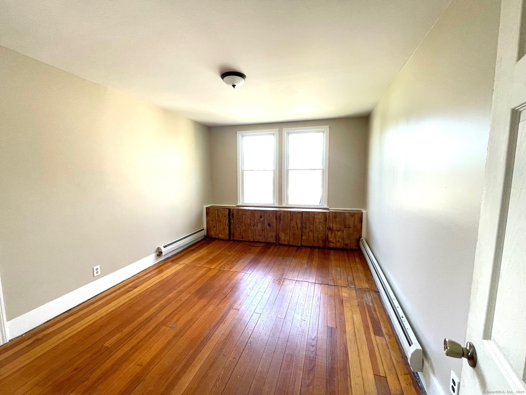 21 Elm Street Ansonia, CT 06401 - Photo 14 of 17 an empty room with wooden floor and windows