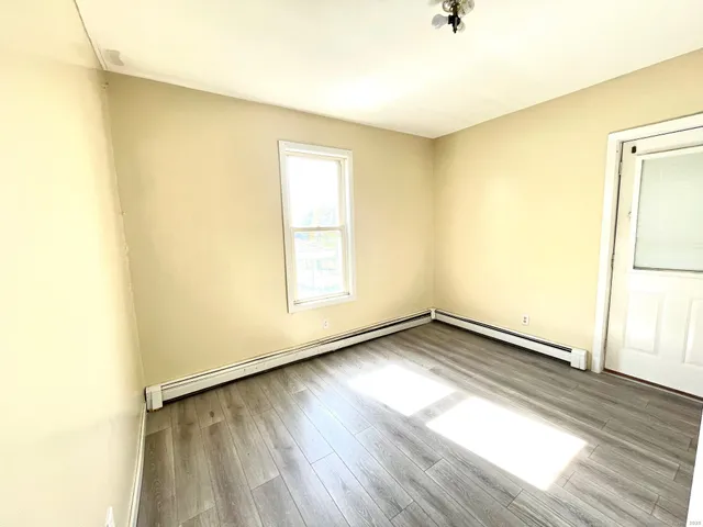 a view of a room with wooden floor and a window