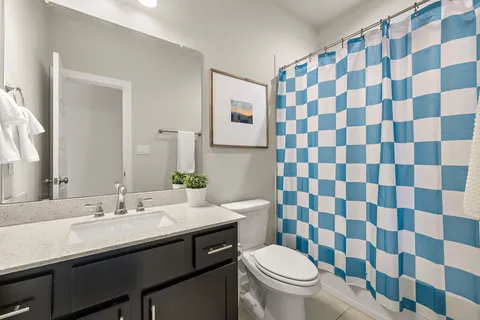 a bathroom with a sink a toilet a shower and a mirror