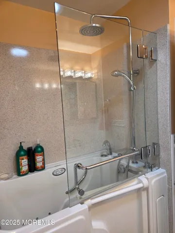 a bathroom with a tub sink and mirror