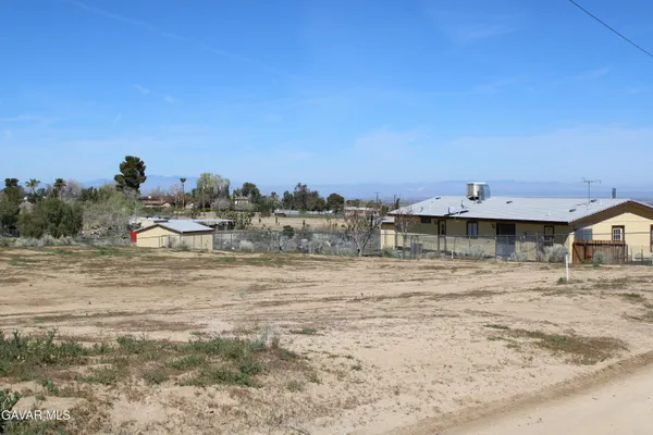 a view of a dry yard with a house