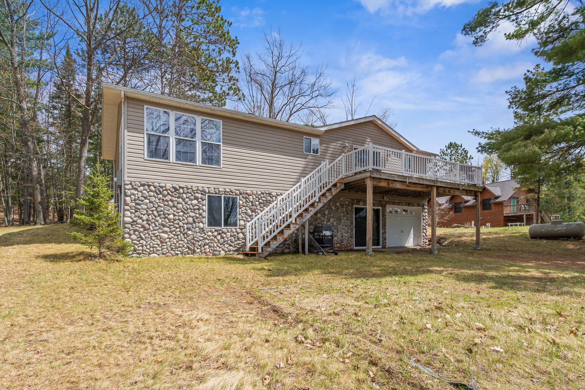 12503 Small Road Hayward, WI 54843 - Photo 14 of 36 Great curb appeal with the stone accent wall and beautiful deck overlooking the lake.