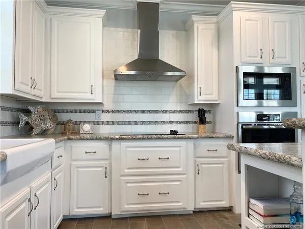 a kitchen with white cabinets and appliances