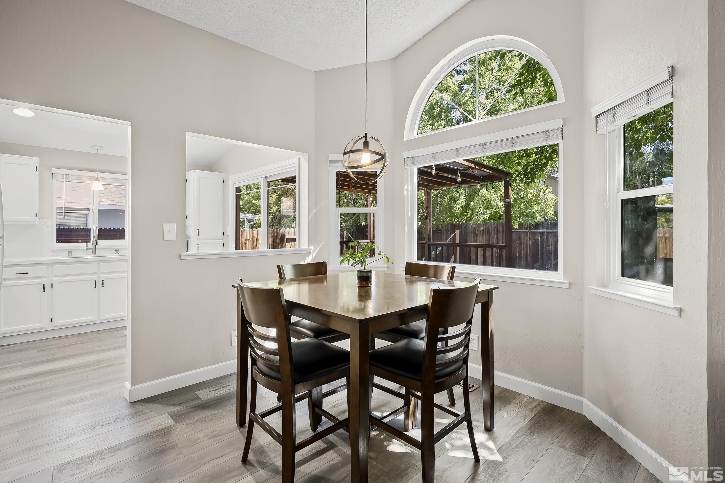 1306 Valley Creek Road Reno, NV 89523 - Photo 8 of 40 a view of a dining room with furniture large windows and wooden floor