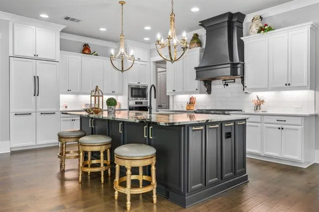 a kitchen with kitchen island granite countertop a sink cabinets and wooden floor