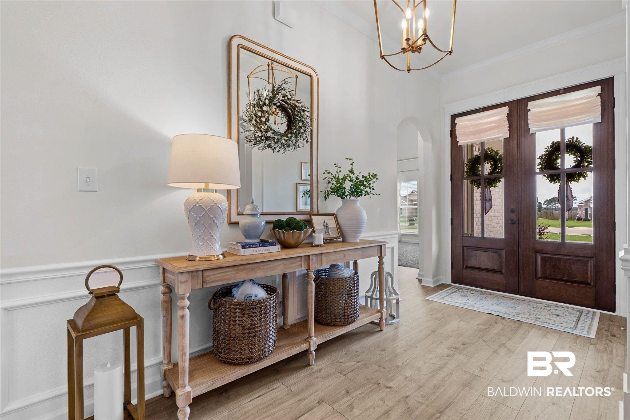 9074 Moses Way Theodore, AL 36582 - Photo 6 of 52 Entryway featuring light wood-finish flooring, wainscoting, and an arched doorway