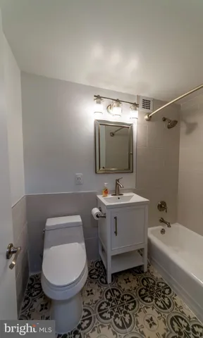 a bathroom with a sink toilet mirror and bathtub