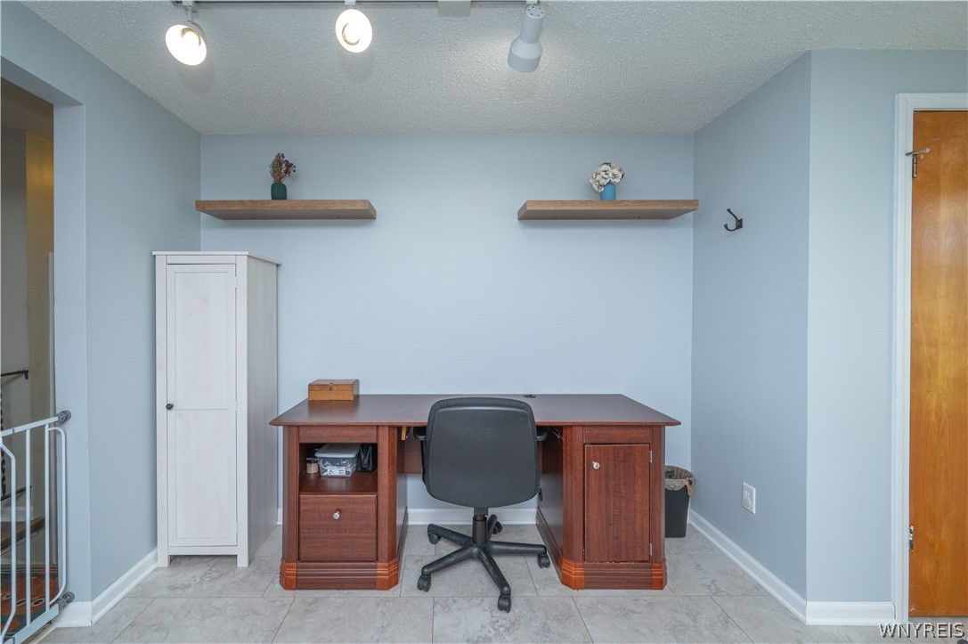 6463 Ward Road Sanborn, NY 14132 - Photo 10 of 49 Tiled flooring and track lighting enhance this versatile home office setup.