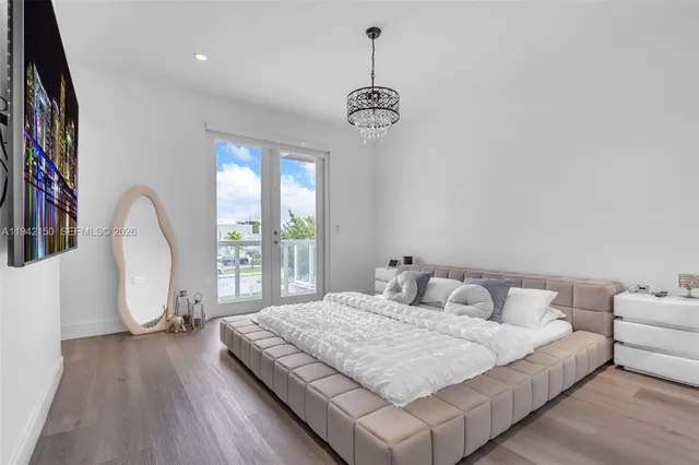 a bedroom with a large bed and a chandelier