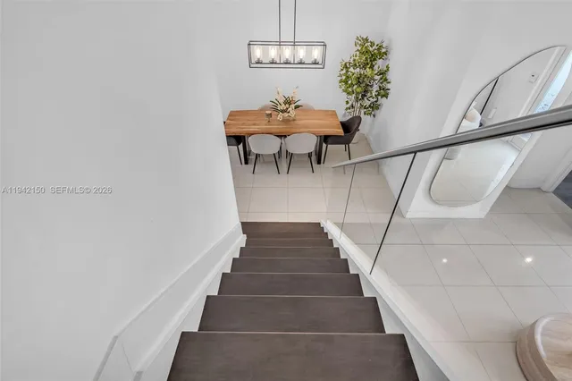 a living room with furniture a chandelier and a floor to ceiling window