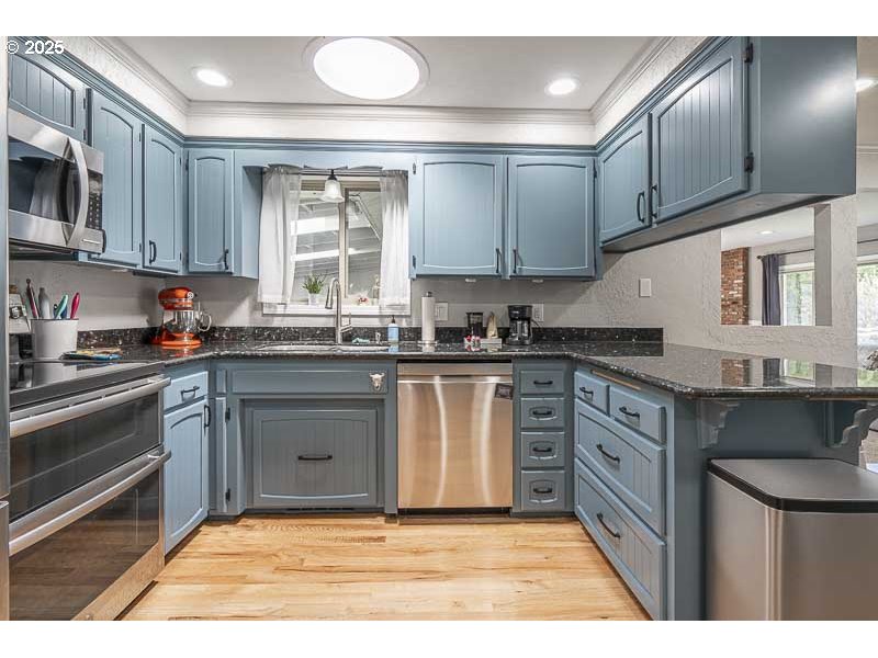 1216 Northeast Montgomery Place Albany, OR 97321 - Photo 11 of 47 a kitchen with stainless steel appliances granite countertop a stove a sink and a microwave