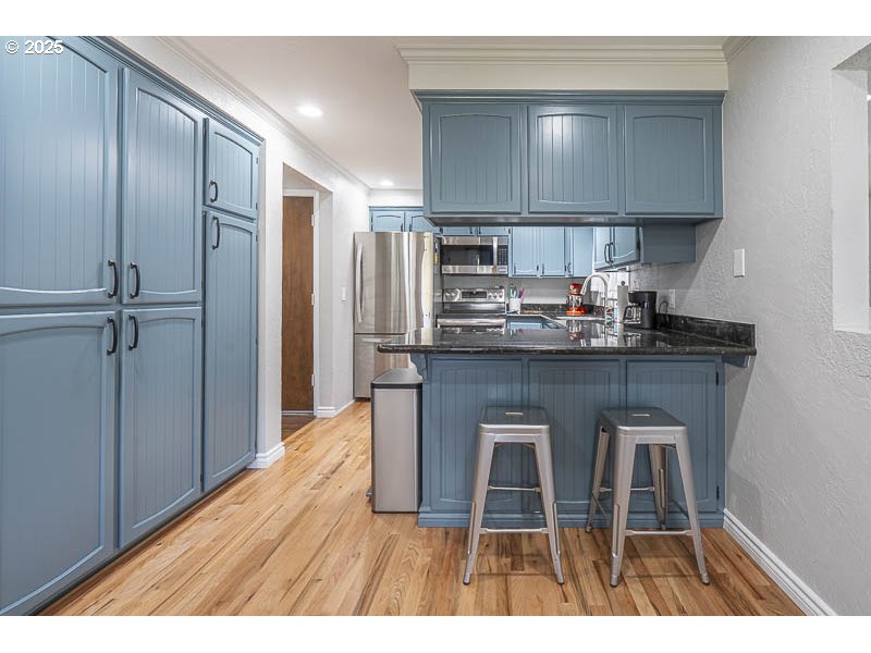 1216 Northeast Montgomery Place Albany, OR 97321 - Photo 12 of 47 a kitchen with kitchen island granite countertop wooden cabinets and a refrigerator