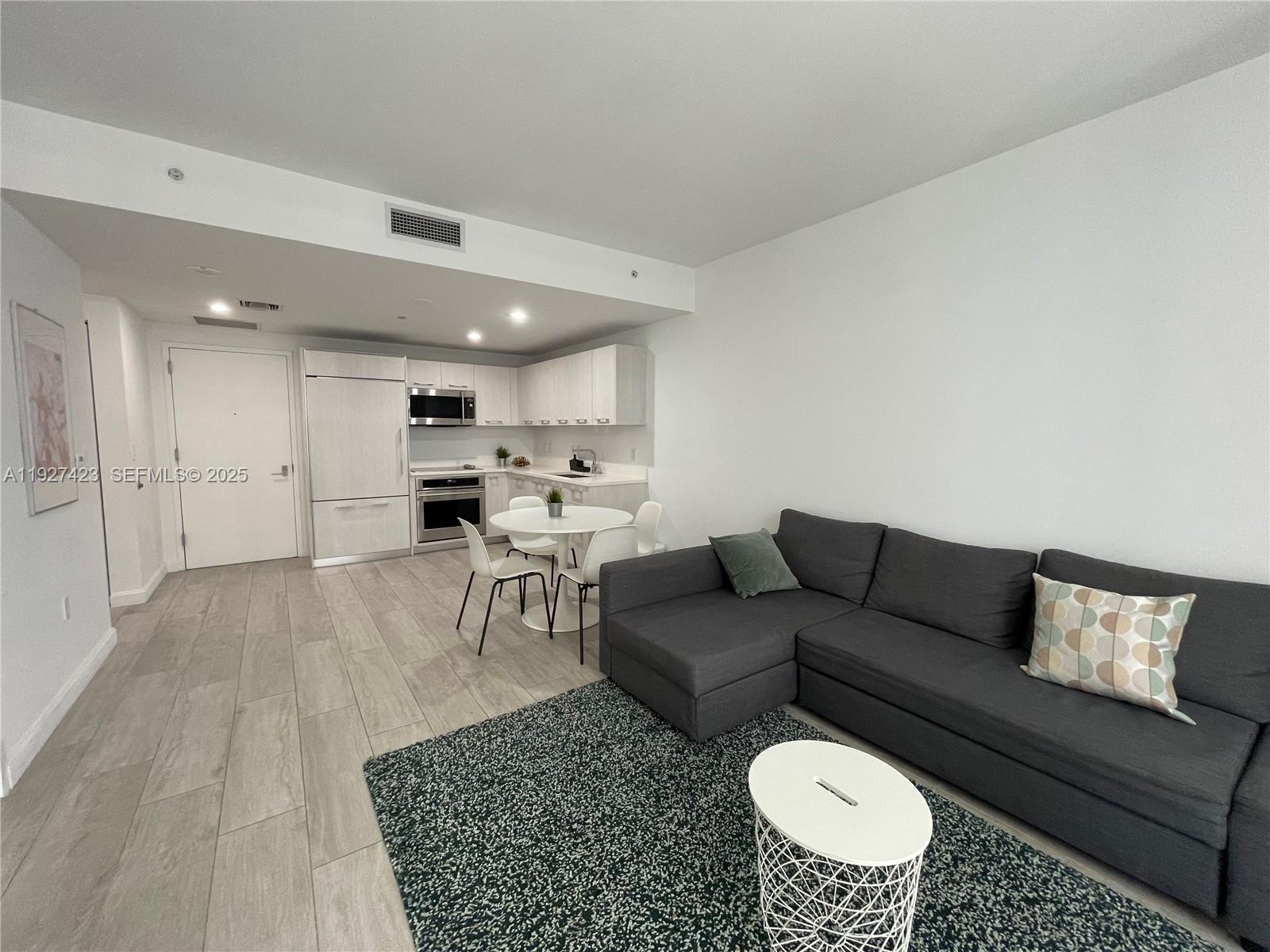 45 Southwest 9th Street, Unit 1407 Miami, FL 33130 - Photo 2 of 10 a living room with furniture and a rug