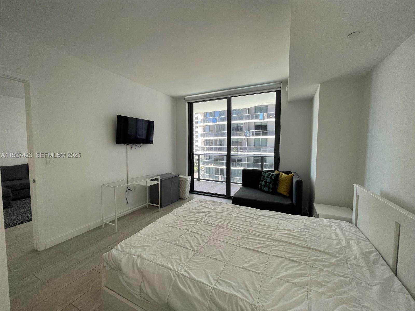 45 Southwest 9th Street, Unit 1407 Miami, FL 33130 - Photo 6 of 10 a bedroom with a bed and a flat screen tv
