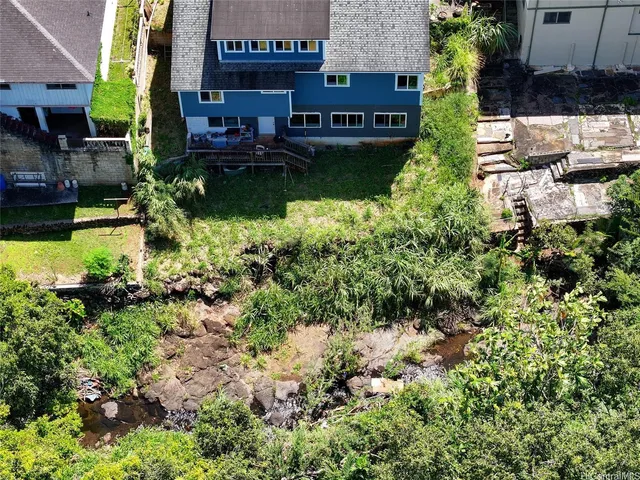 an aerial view of a house with a yard and lake view