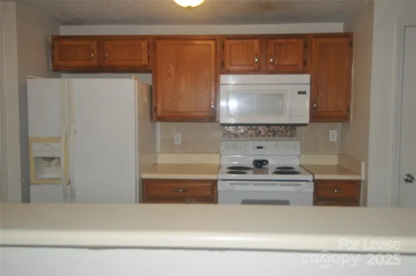 a kitchen with granite countertop a stove and a refrigerator