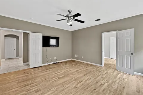 a view of an empty room with wooden floor