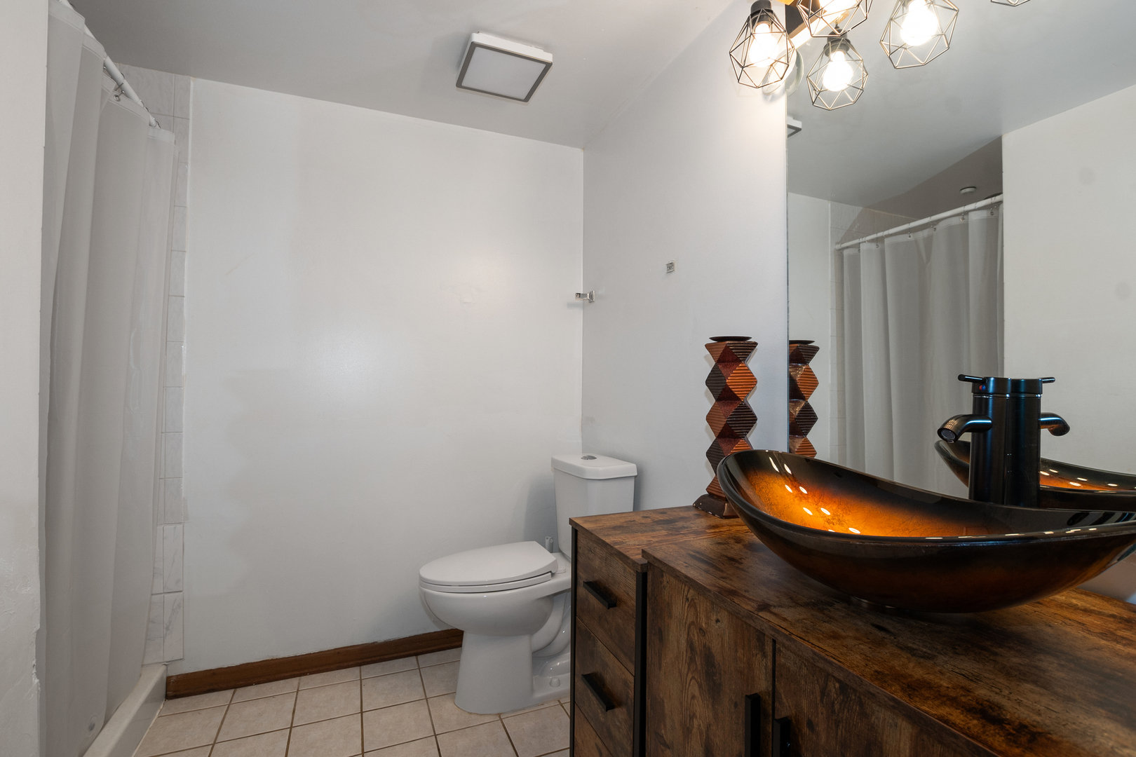 928 East 153rd Street Phoenix, IL 60426 - Photo 18 of 24 a bathroom with a sink a toilet and a mirror