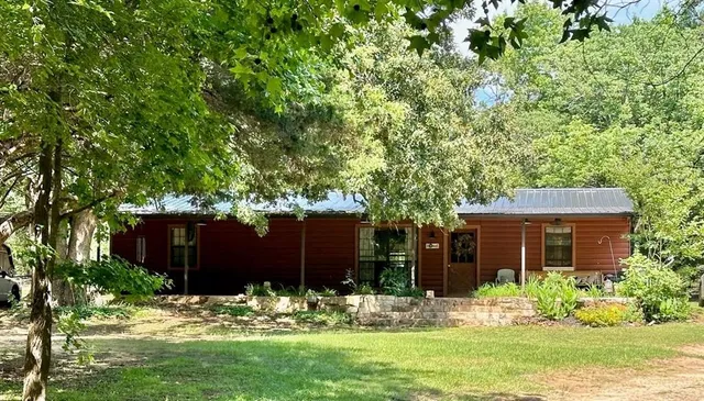a view of a house with backyard and a tree