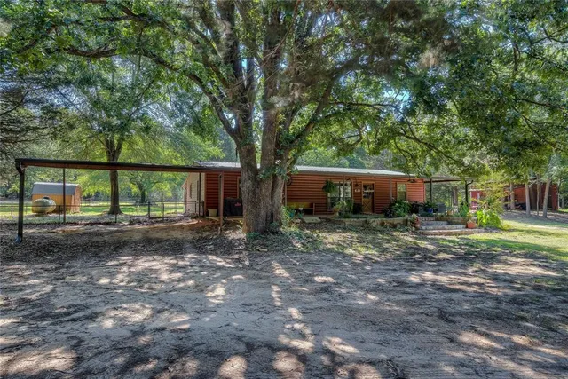 a view of a chair and table in back yard of a house