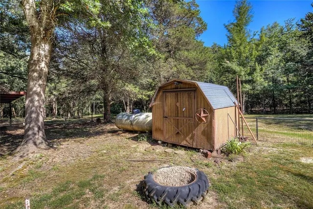 an aerial view of residential houses with outdoor space and trees
