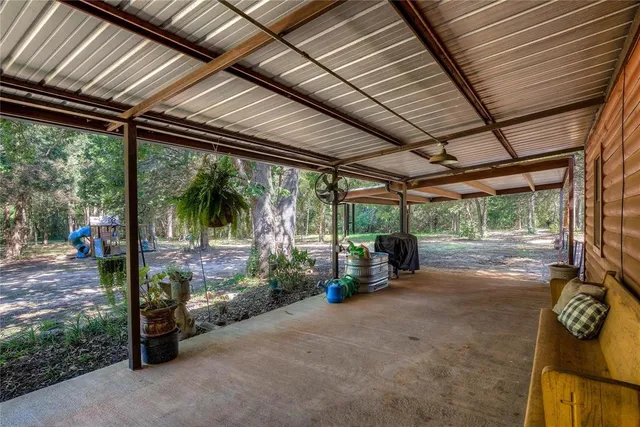a living room with patio furniture and a garden
