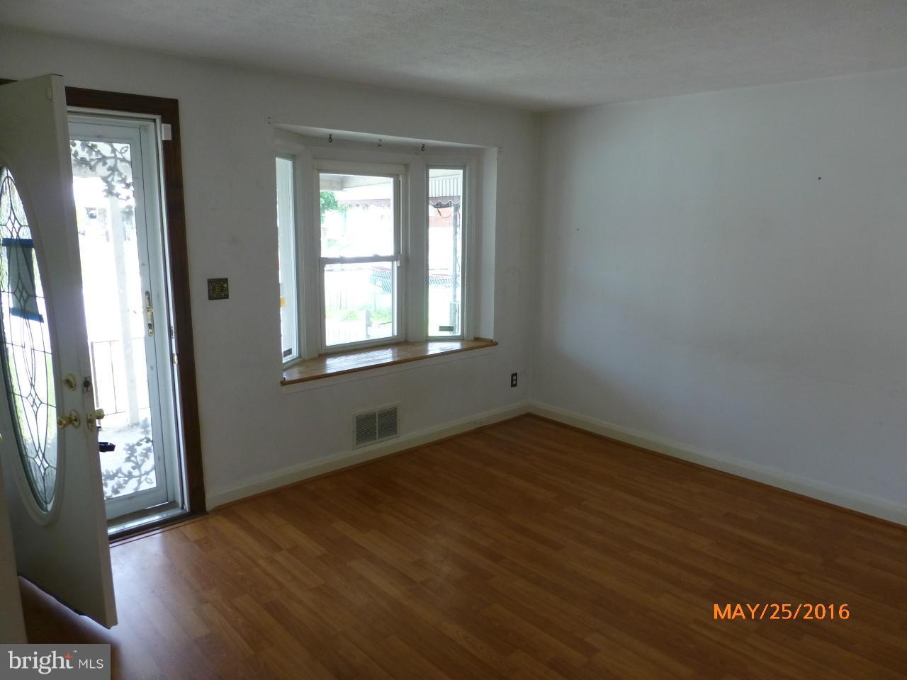 949 Middlesex Road Baltimore, MD 21221 - Photo 8 of 17 an empty room with wooden floor and windows
