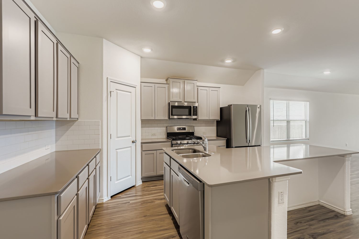 128 Concho Brook Bend Georgetown, TX 78626 - Photo 7 of 28 a kitchen with stainless steel appliances a refrigerator stove microwave and sink