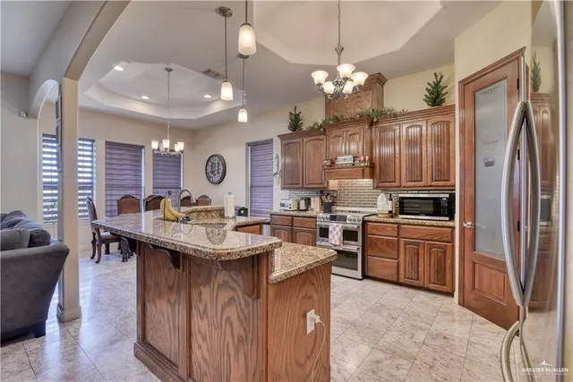 a kitchen with stainless steel appliances granite countertop a sink a stove and a refrigerator