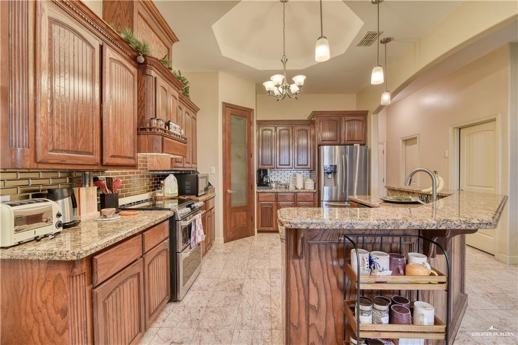 2016 South 48th Street McAllen, TX 78503 - Photo 5 of 9 a kitchen with kitchen island granite countertop stainless steel appliances a sink stove and cabinets