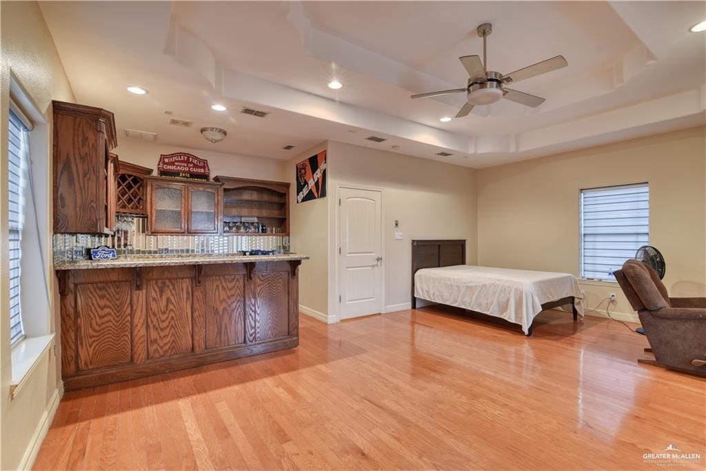 2016 South 48th Street McAllen, TX 78503 - Photo 6 of 9 a spacious bedroom with a large bed a chandelier and closet